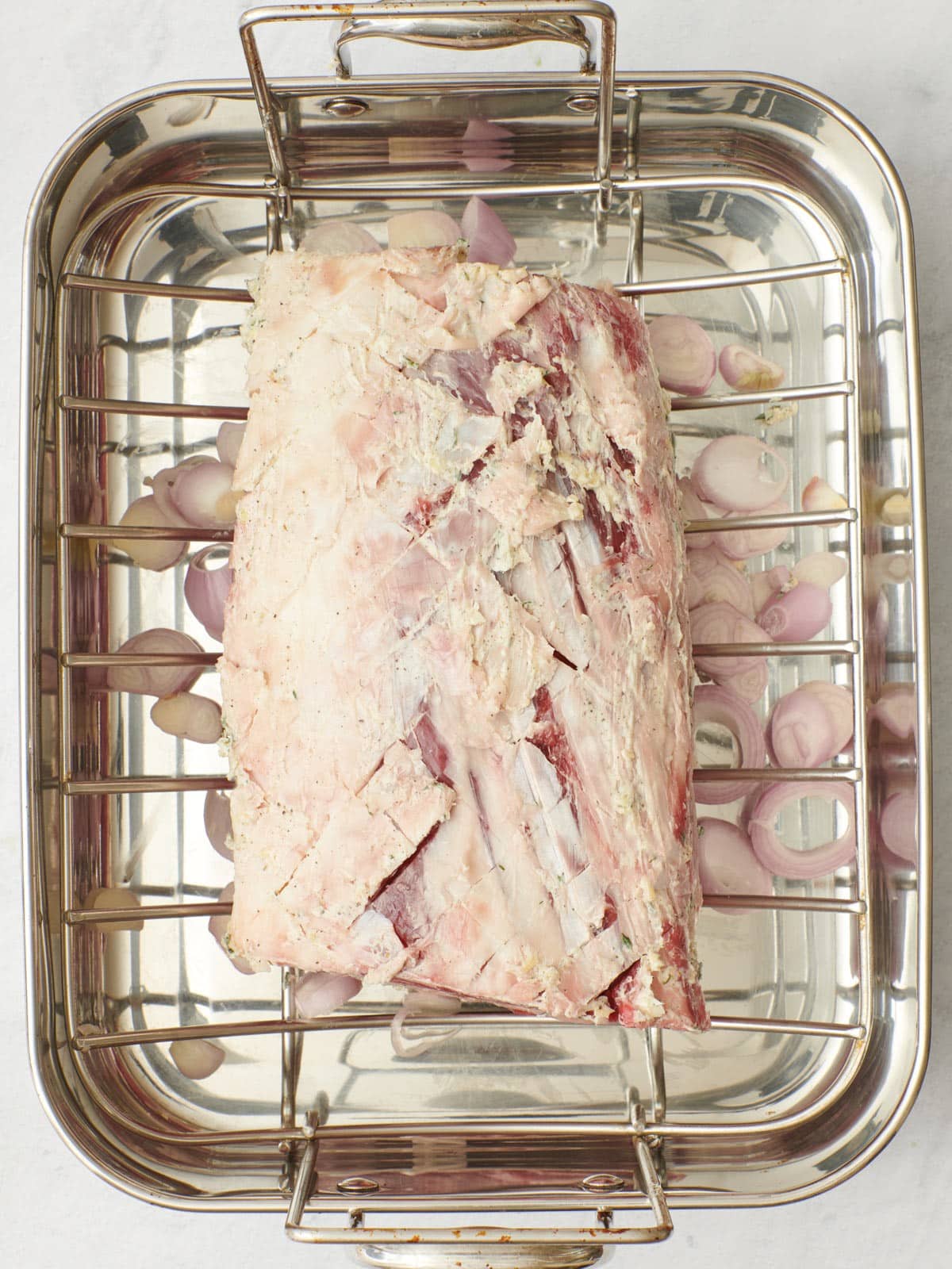 Shallots in an even layer in a roasting pan.