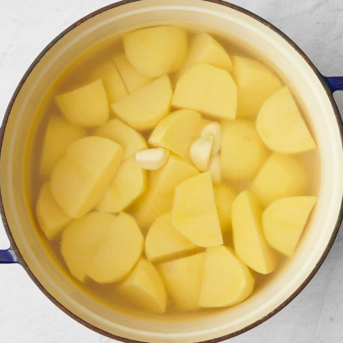 Potatoes, garlic in a large pot with water.