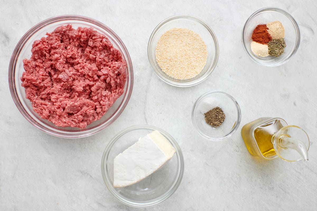 Ingredients for recipe: ground beef, brie cheese, breadcrumbs, salt and pepper, spices, and oil.