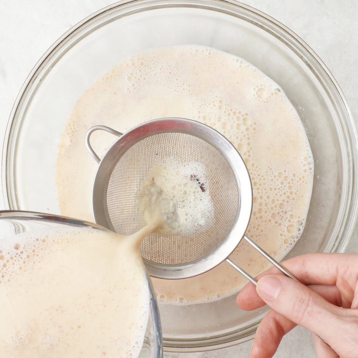 Mixture being strained through a fine mesh sieve.