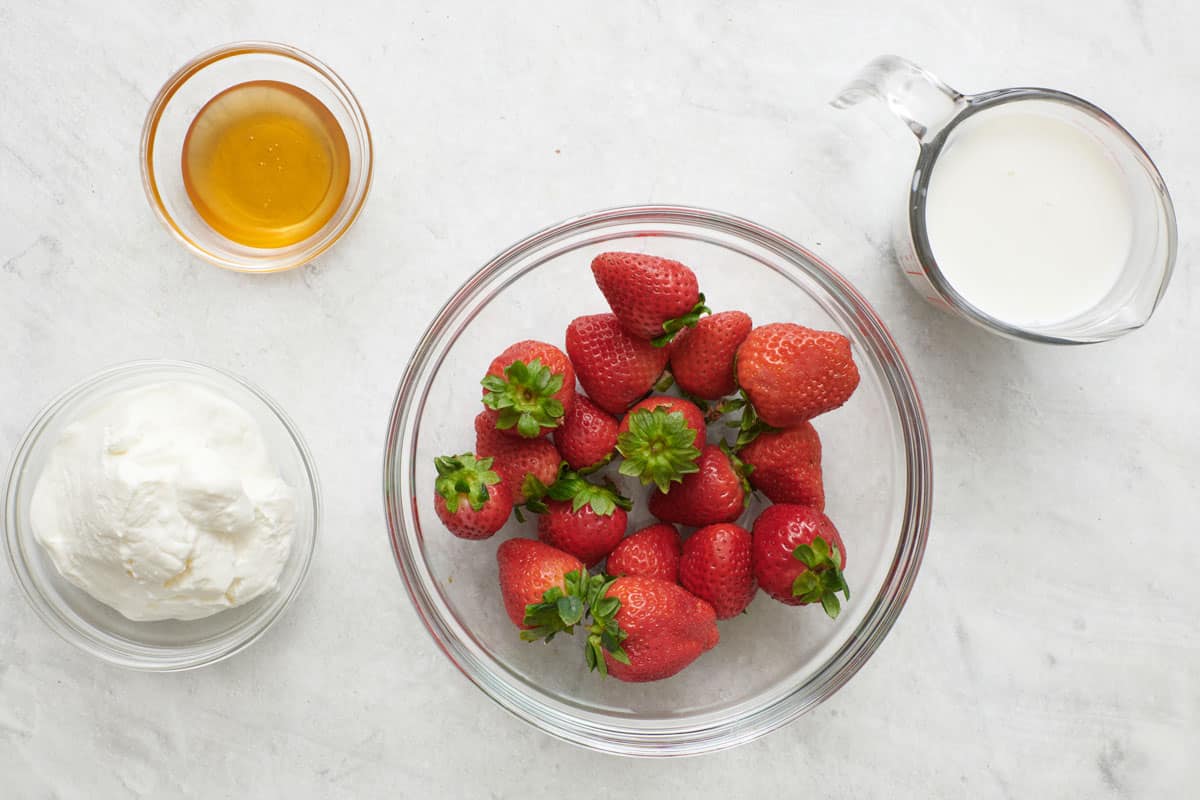 Ingredients for recipe: yogurt, honey, strawberries, and milk.