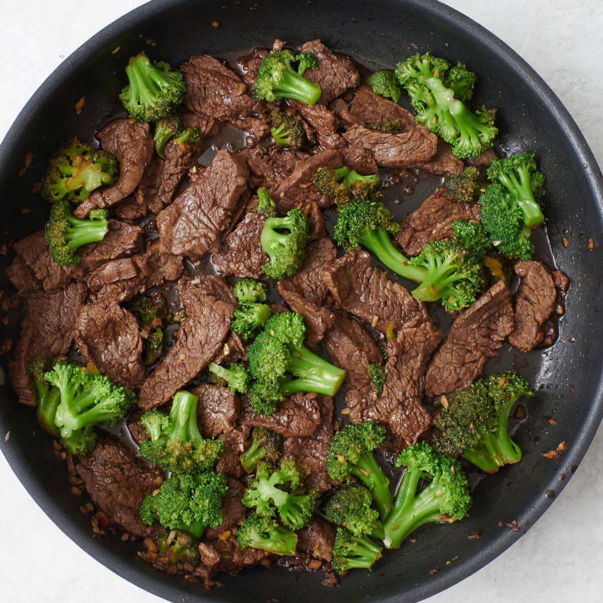 After tossed together and coated with sauce.