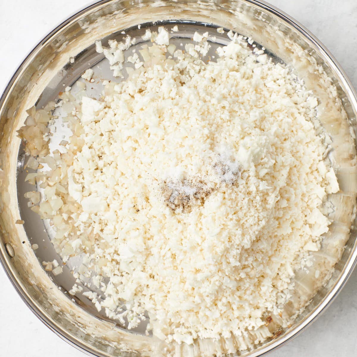 Cauliflower rice, salt and pepper added, before combining.