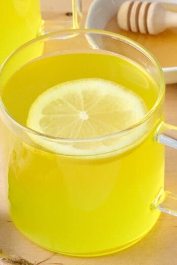 Ginger tea in a glass mug with lemon.