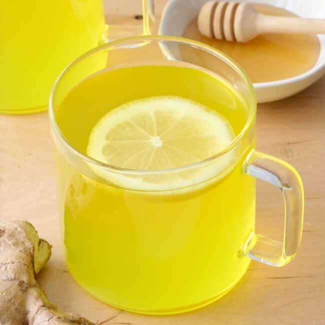 Ginger tea in a glass mug with lemon.