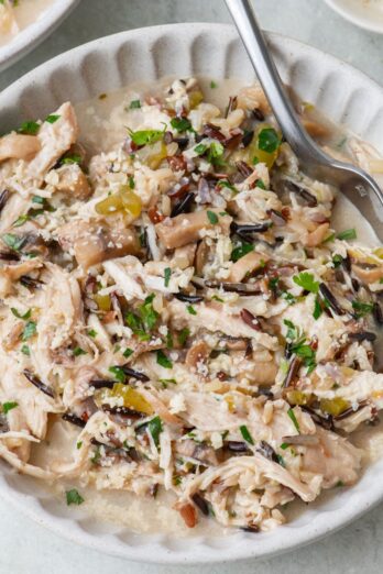 Instant pot chicken and rice in a bowl with spoon dipped in.