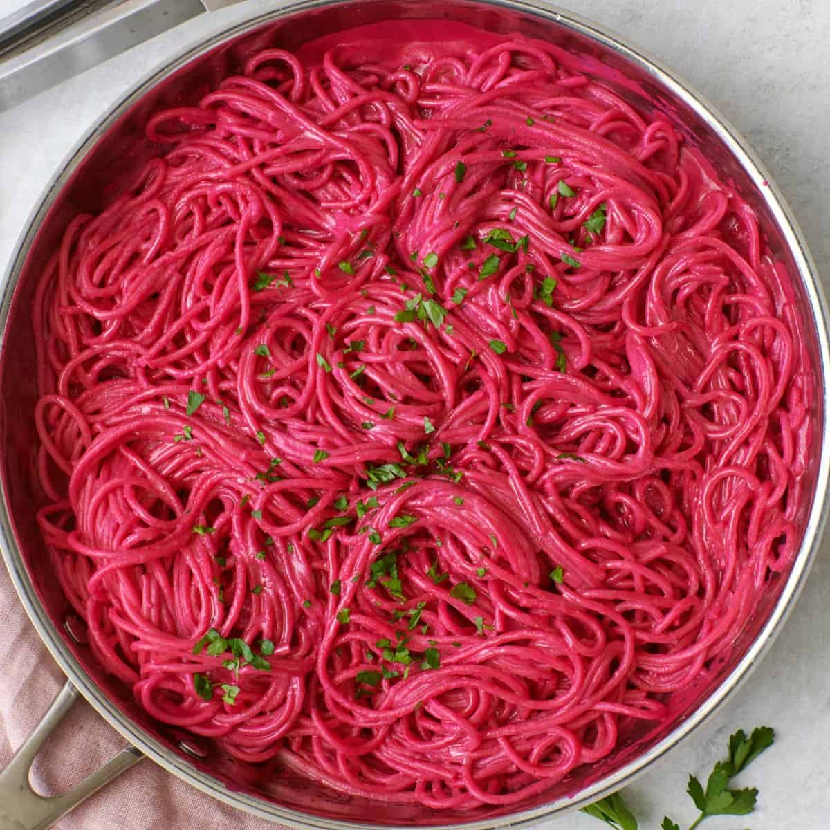 Pink beet pasta in skillet.