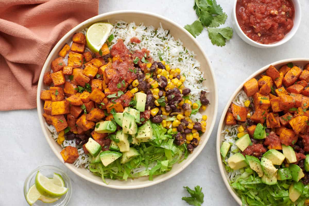 Vegetarian burrito bowl with toppings and a fork dipped inside bowl.