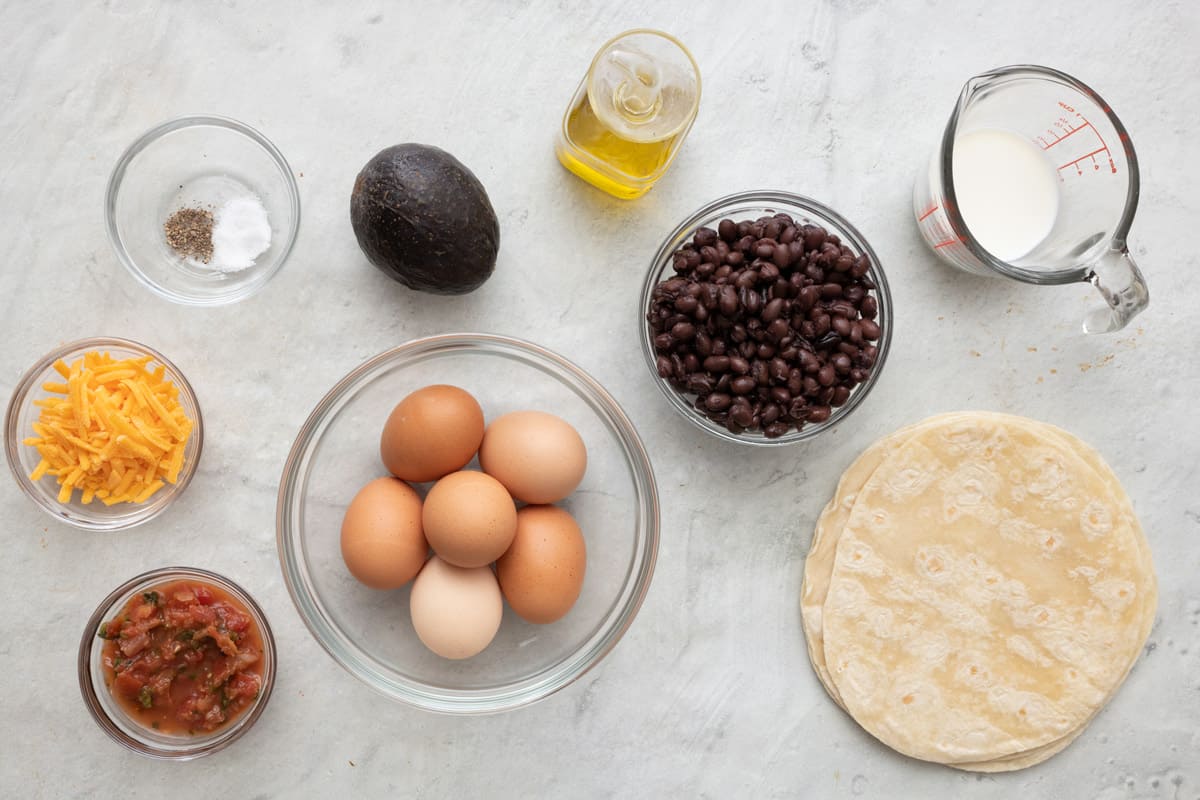 Ingredients to make recipe: Eggs, tortillas, beans, avocado, cheese, salsa, olive oil, milk, salt, and black pepper.