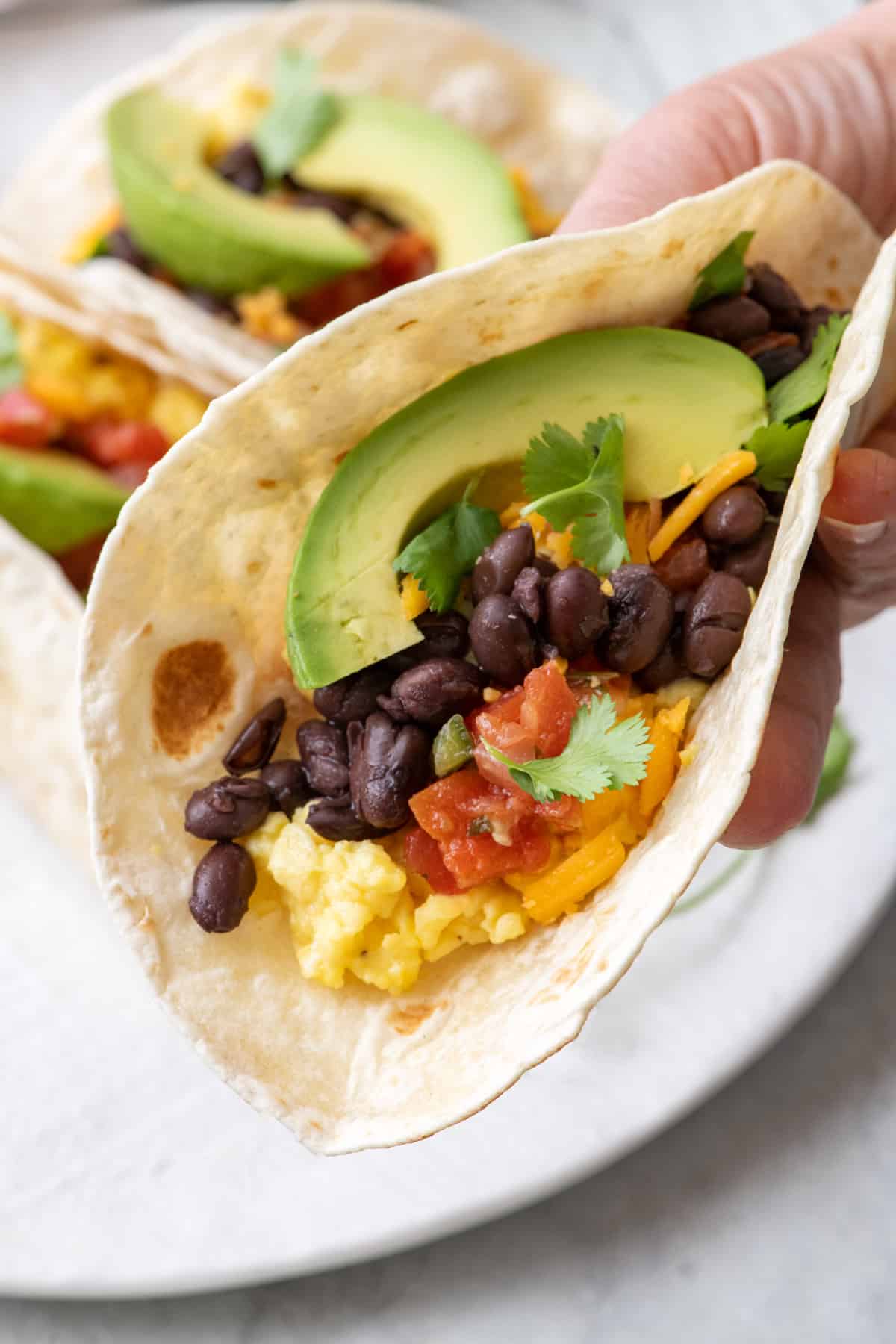 Closeup of breakfast taco, ready to bite.
