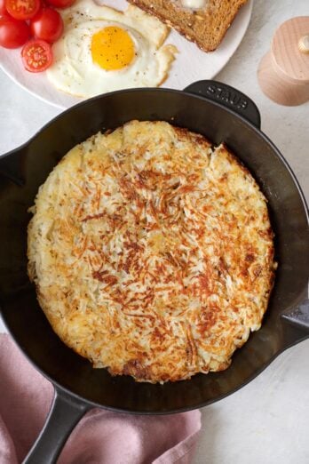 Crispy hash browns in a cast iron skillet pan.
