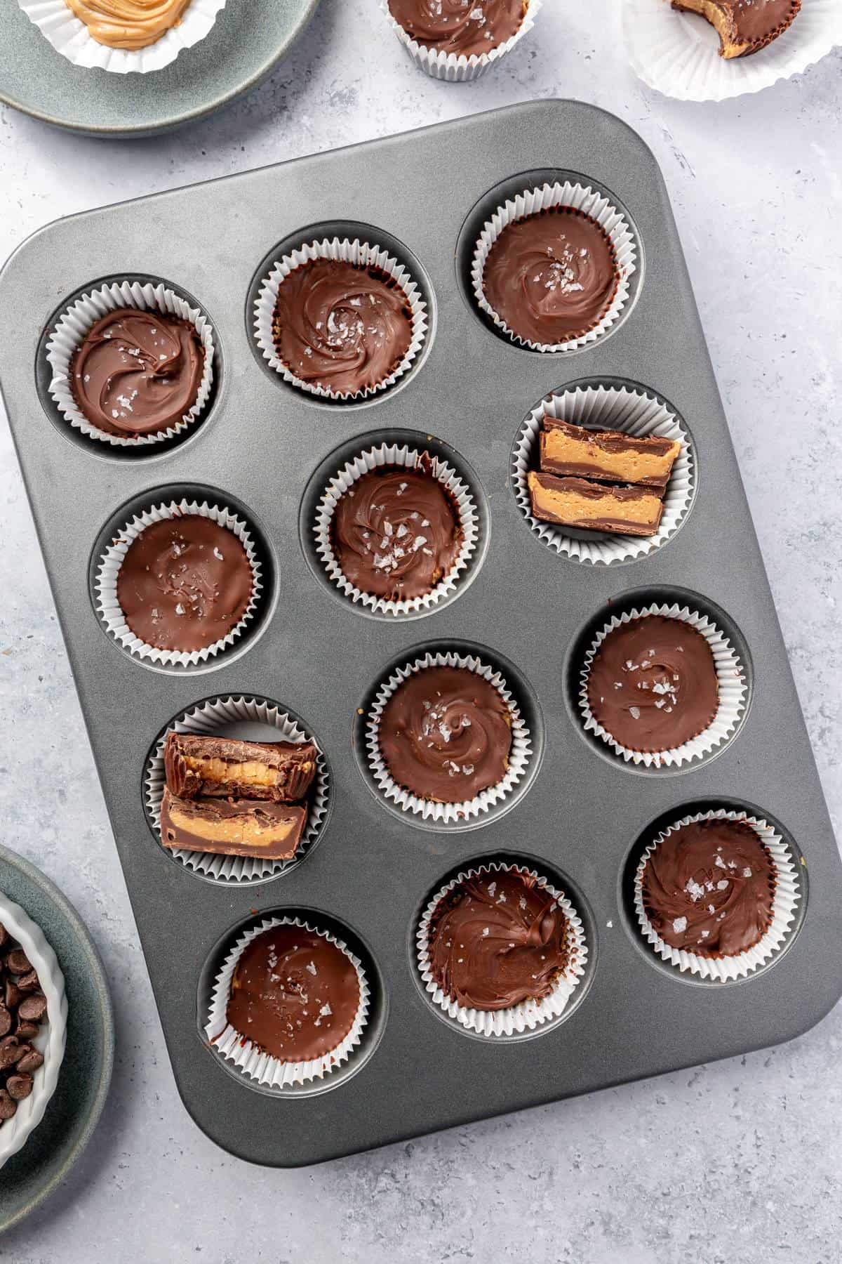 Homemade peanut butter cups in a paper-lined muffin tin.