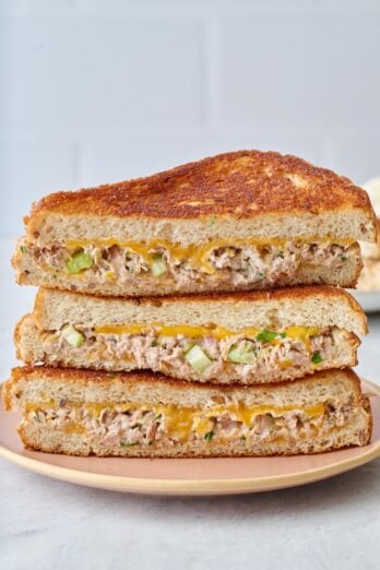 Stack of tuna melts showing the cheesy sandwich from the cut side.