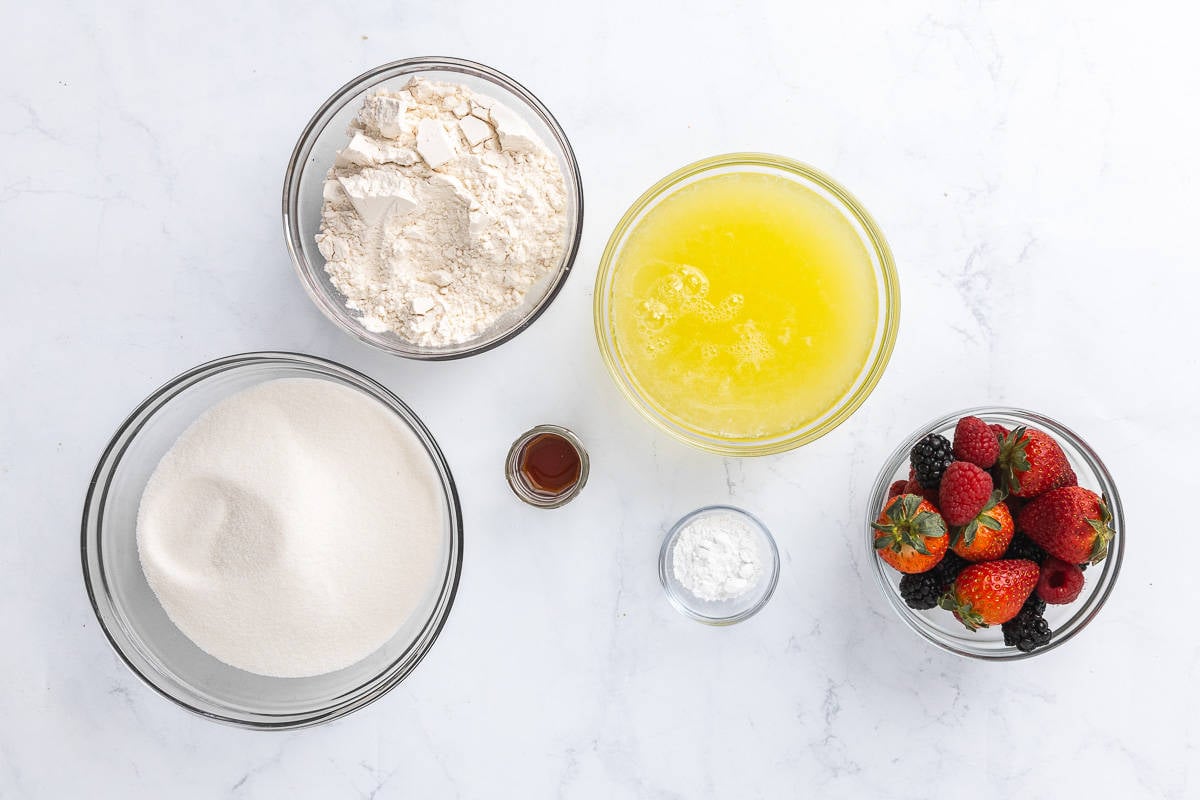 Ingredients for recipe in individual bowls: sugar, flour, vanilla, cream of tartar, egg whites.