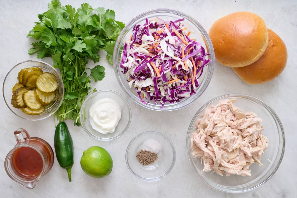Ingredients to make recipe: shredded chicken, bbq sauce, lime, greek yogurt, coleslaw mix, cilantro, jalapeno, salt and pepper, plus buns and pickles.