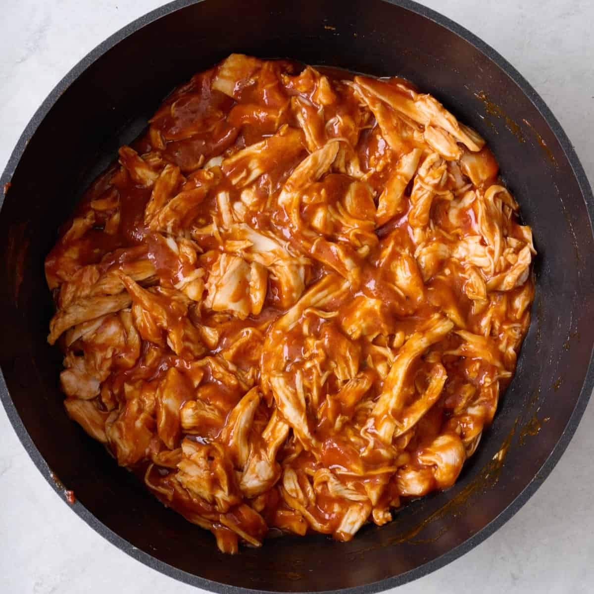 Shredded chicken and bbq sauce in a pot.