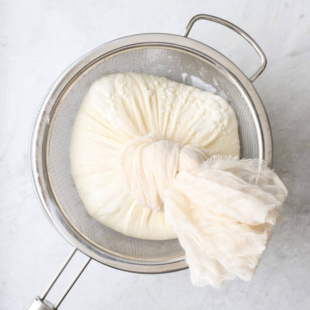 Cheesecloth tied around yogurt.