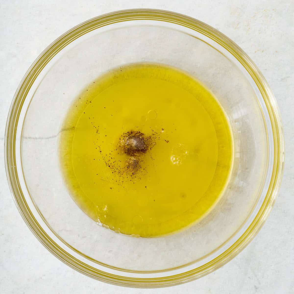 Oil, lemon juice, and spices in a bowl.