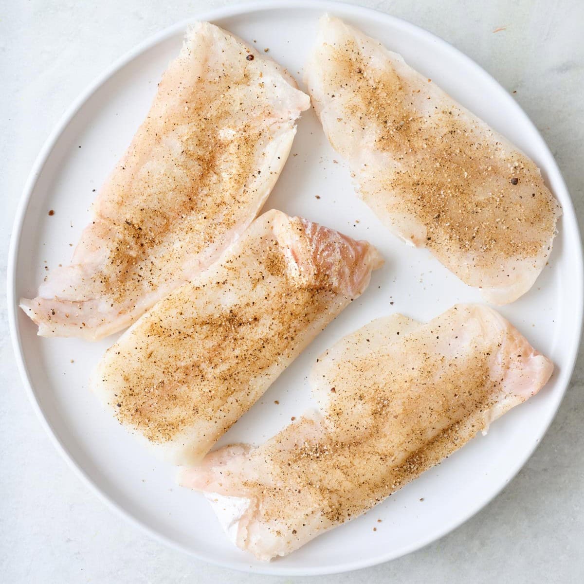 Fish seasoned with salt, pepper, and cumin.