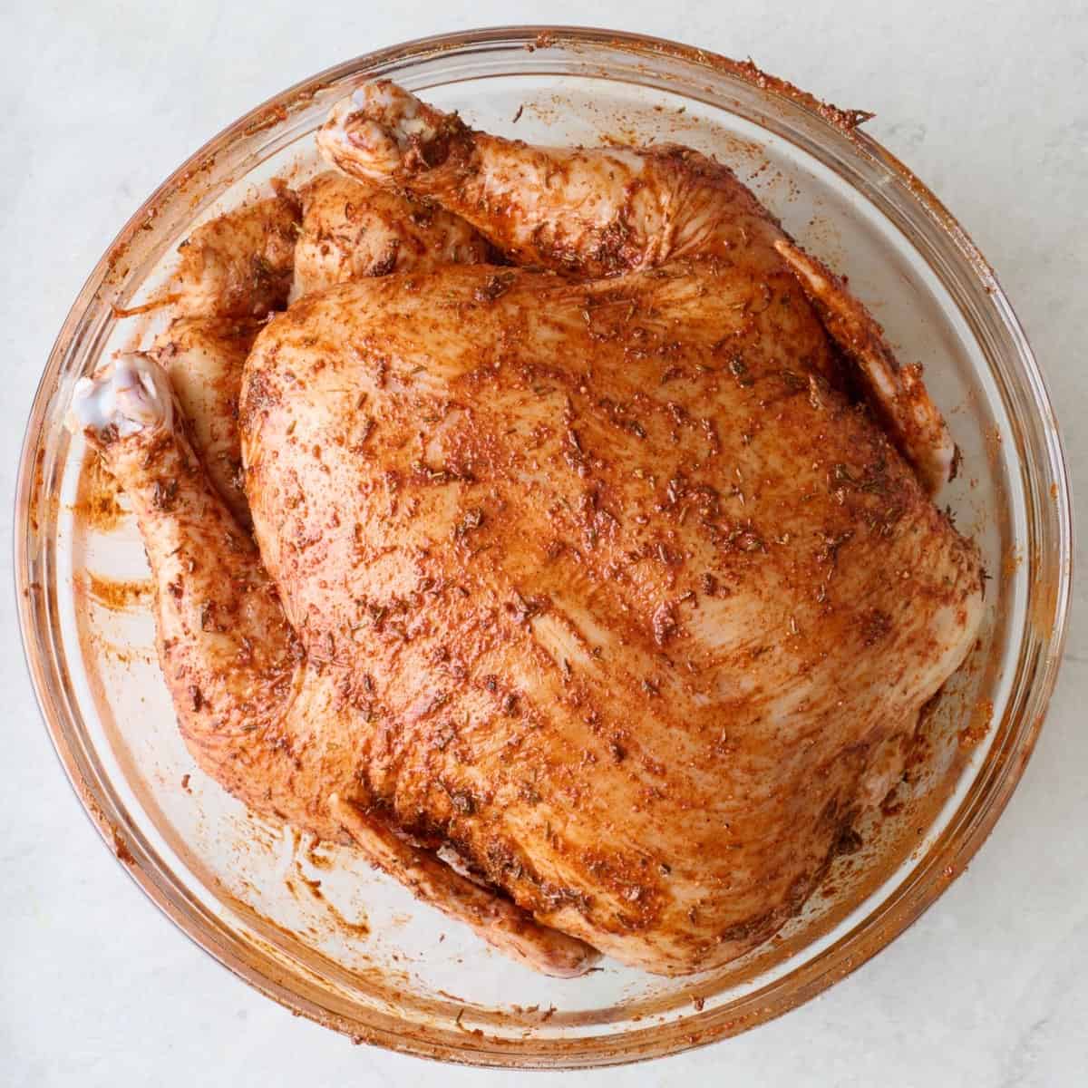 Chicken with seasonings rubbed on it.