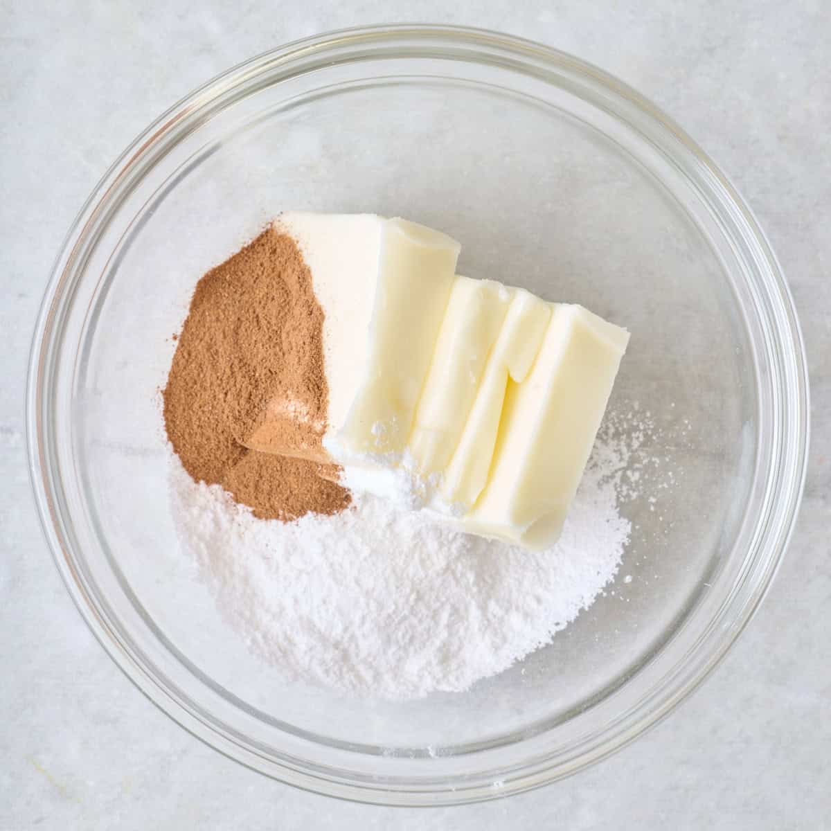 Butter, cinnamon, and powdered sugar in a bowl.