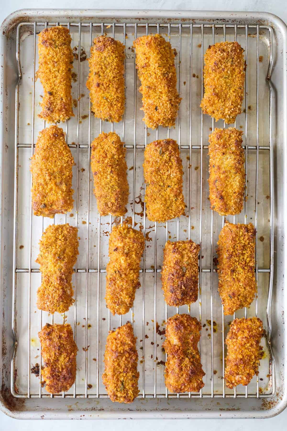 Breaded salmon pieces on a wire rack on top of a sheet pan after baking.