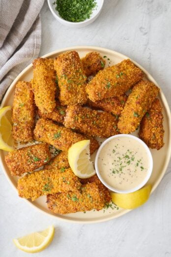 Crispy Salmon Fish Sticks on a plate with a small dish of sauce for dipping.