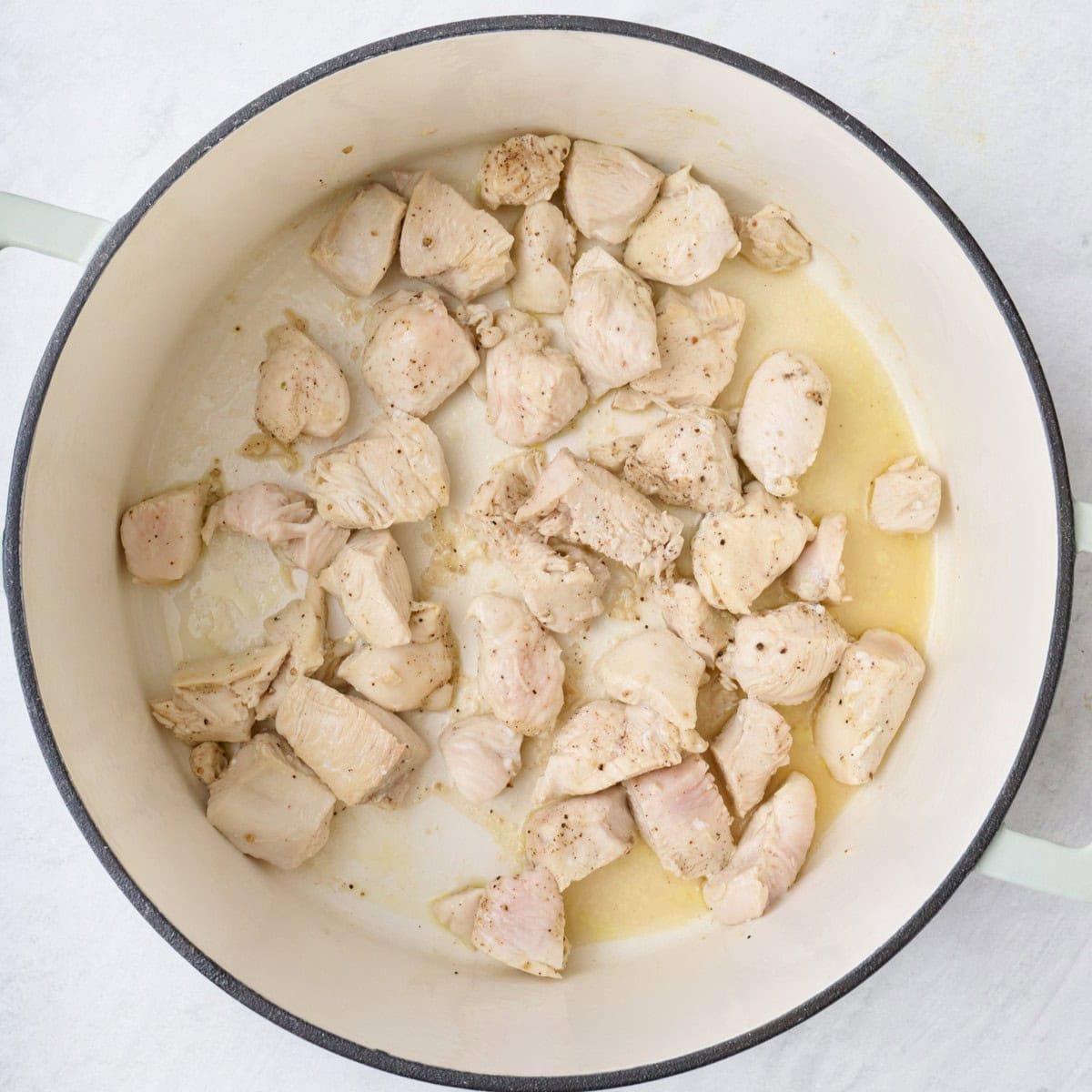Chicken pieces in pot after briefly stir frying.