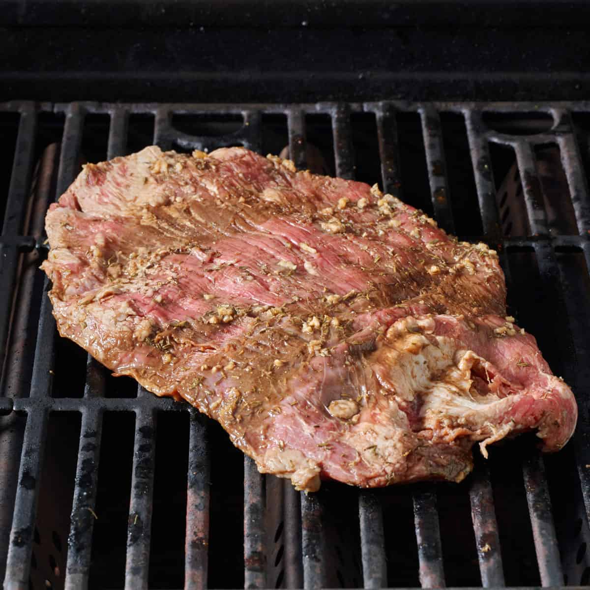 Marinated steak on a grill.