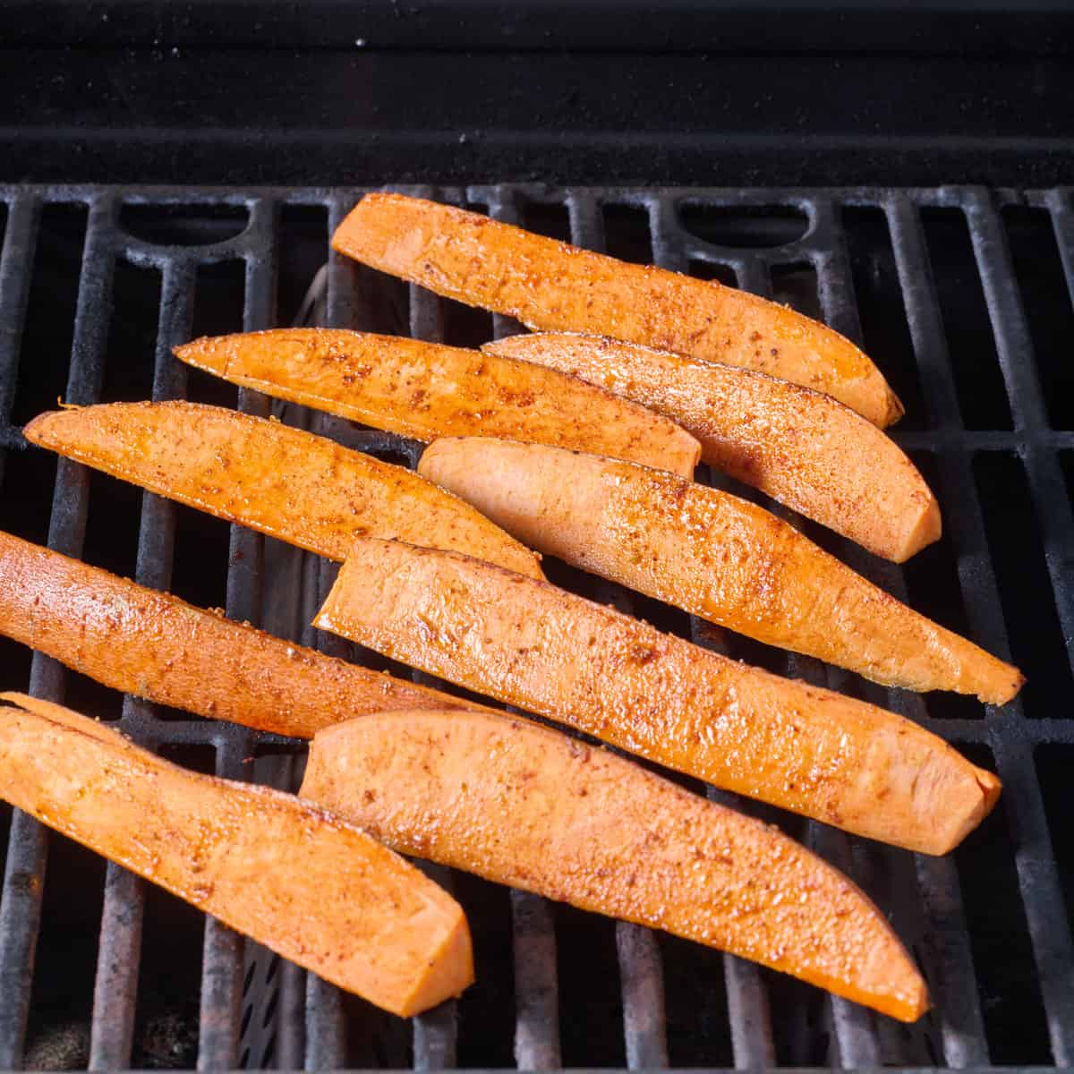 Sweet potato wedges on a grill.