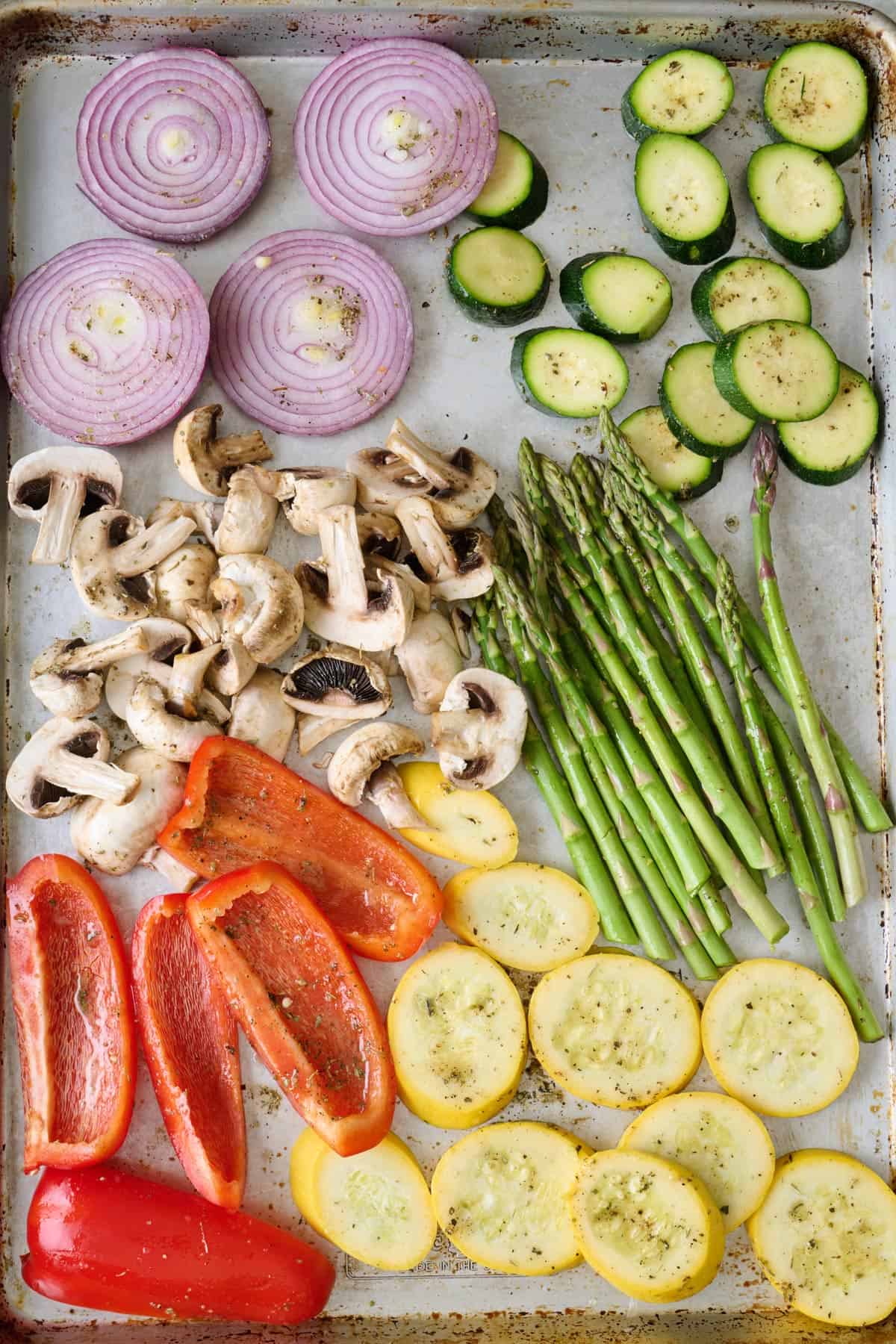 Oil and seasoning added to prepared vegetables for grilling.