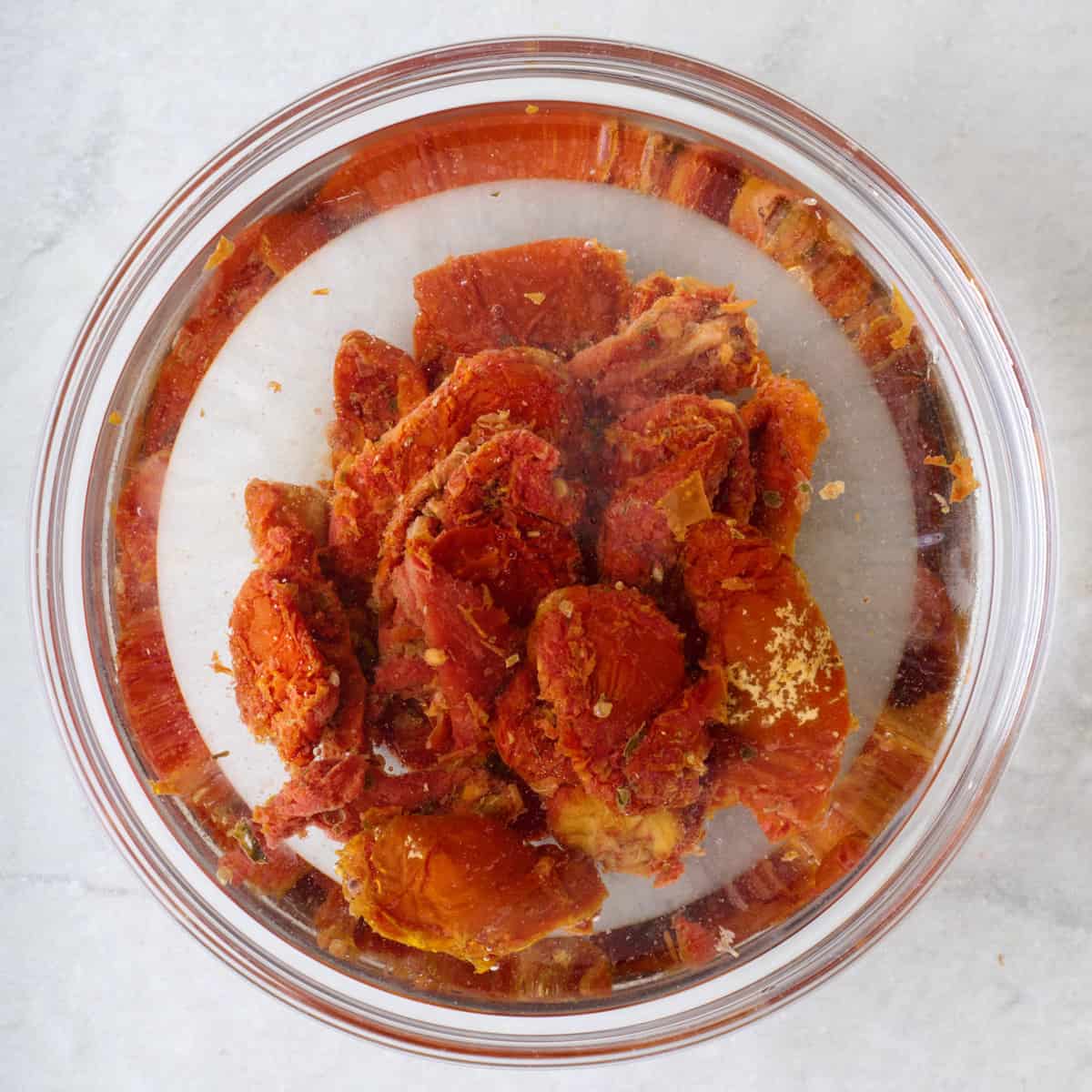 Sundried tomatoes in a bowl of hot water.