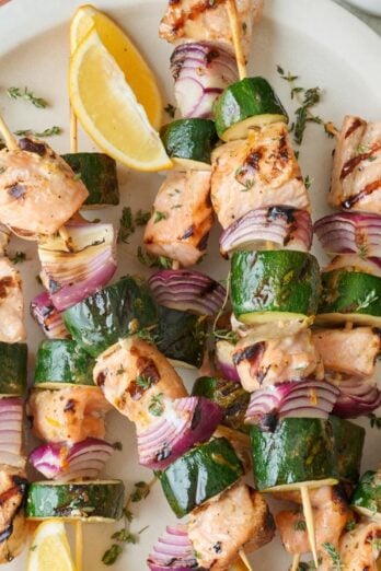 Salmon kabobs with red onions and zucchini slices.