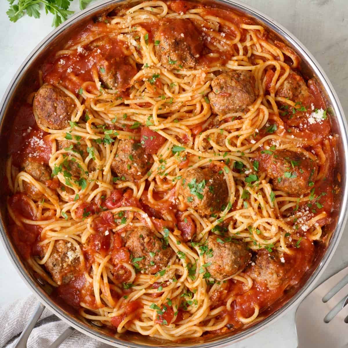 Spaghetti and meatballs after tossing together in skillet.