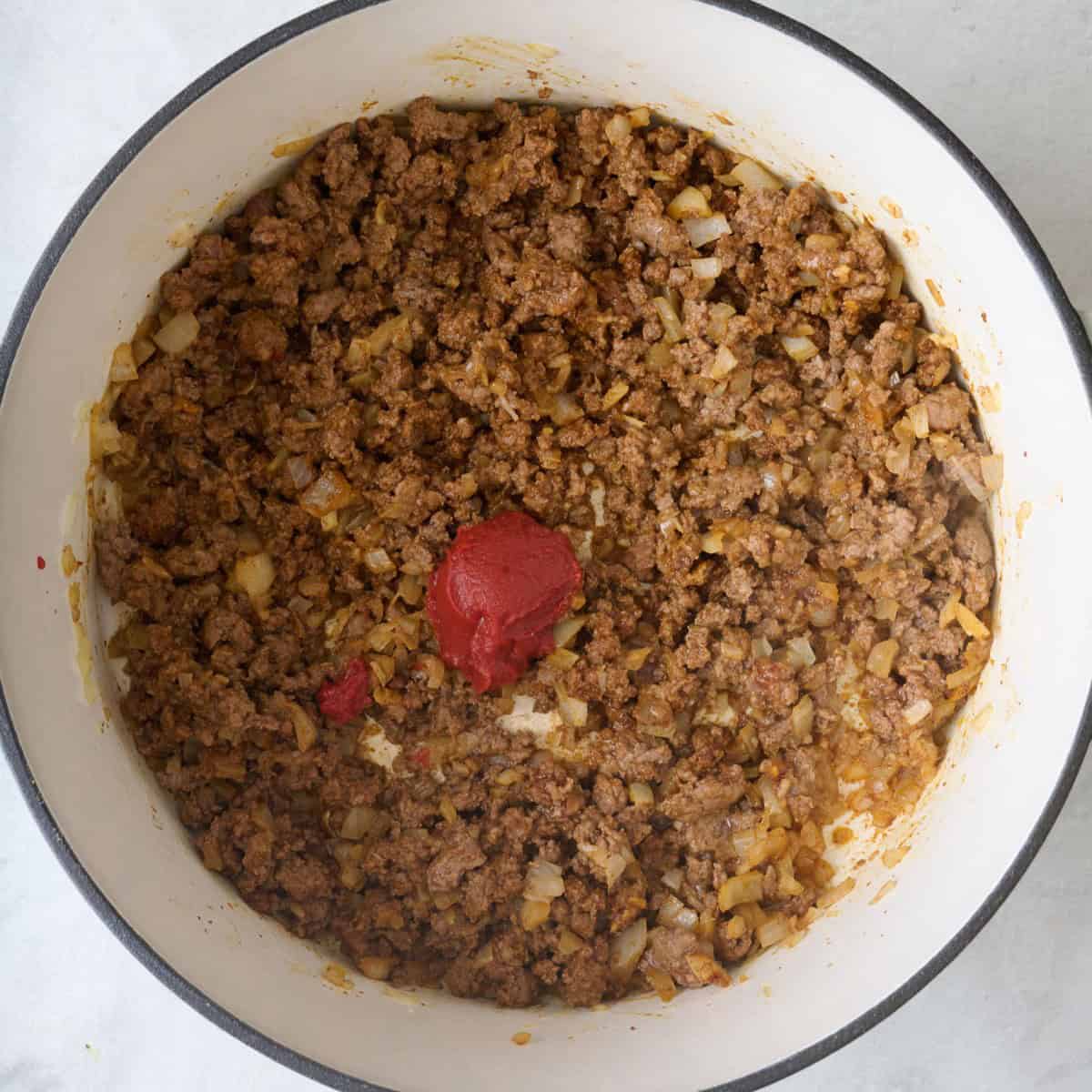 Tomato paste added on top of the cooked beef mixture.