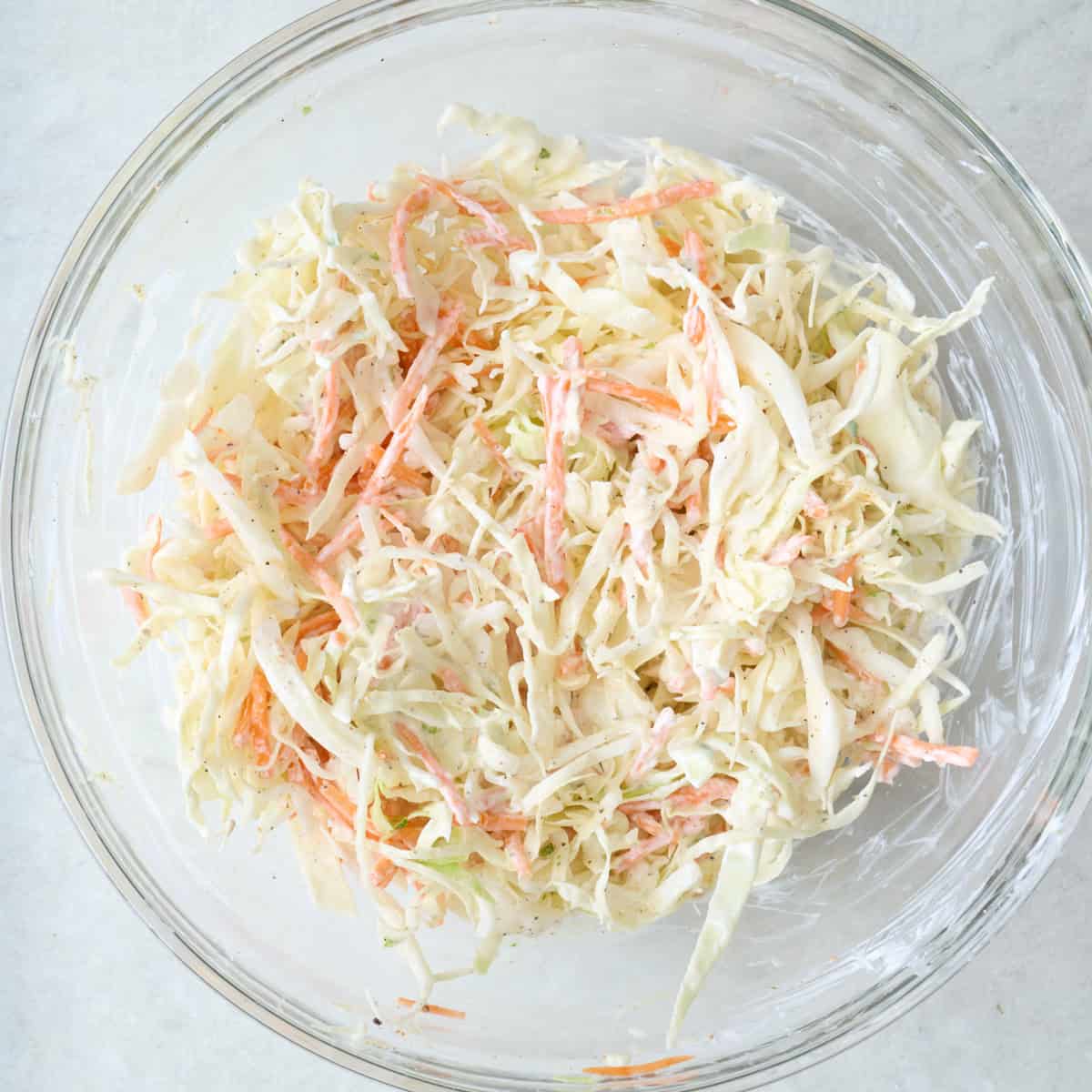 Coleslaw in a large glass bowl.