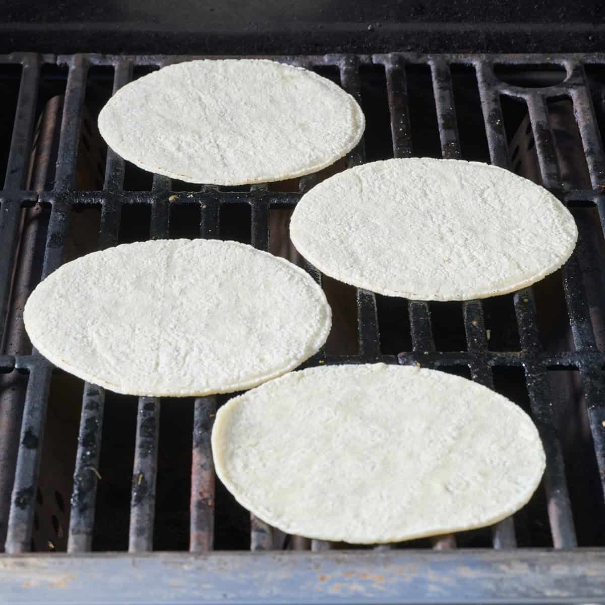 Four tortillas on a gas grill.