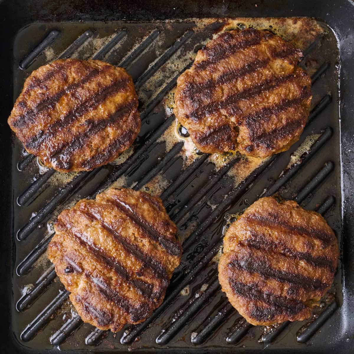Cooked hamburgers on a grill pan.