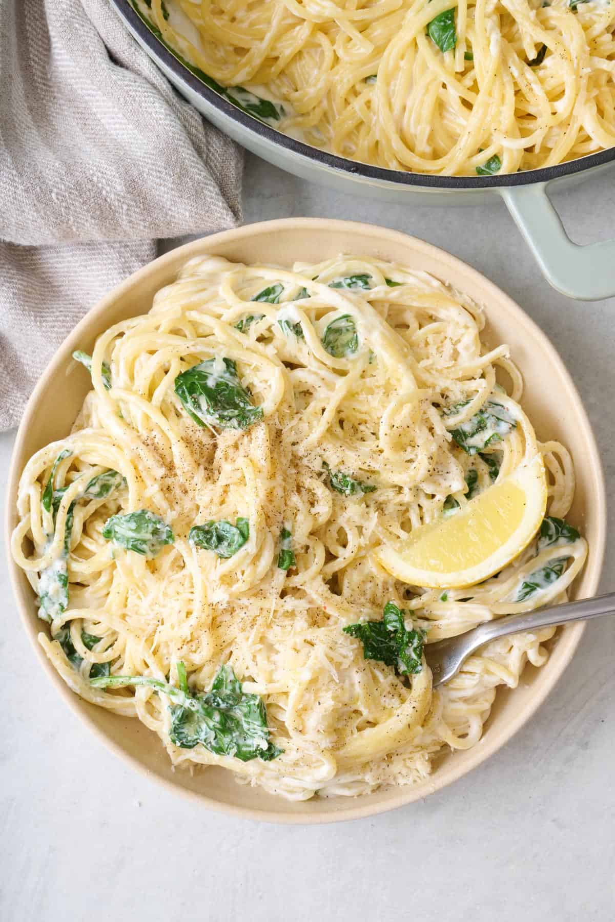 A bowl of lemon ricotta pasta with extra grated cheese on top.