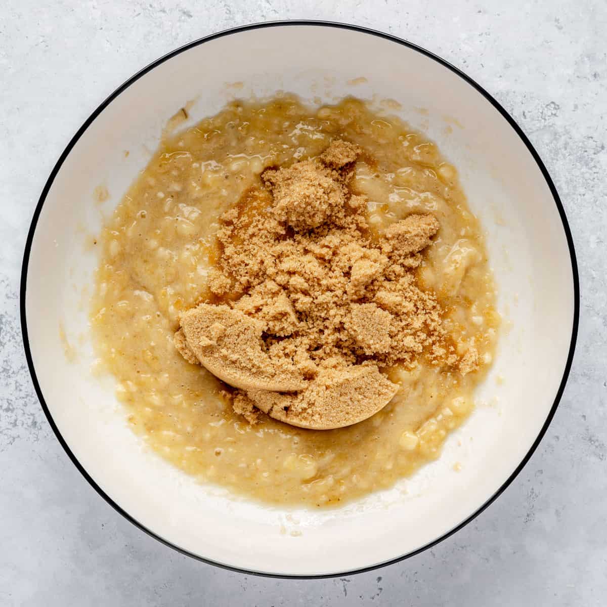 Mashed bananas and brown sugar in a mixing bowl.