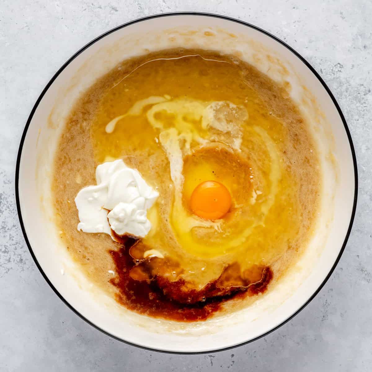 Wet ingredients for mini banana muffins in a mixing bowl.