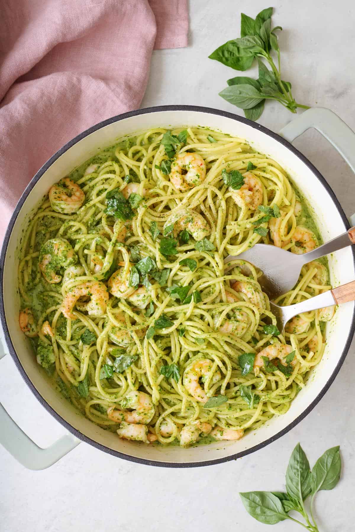 Shrimp pesto pasta in pot garnished with extra basil.