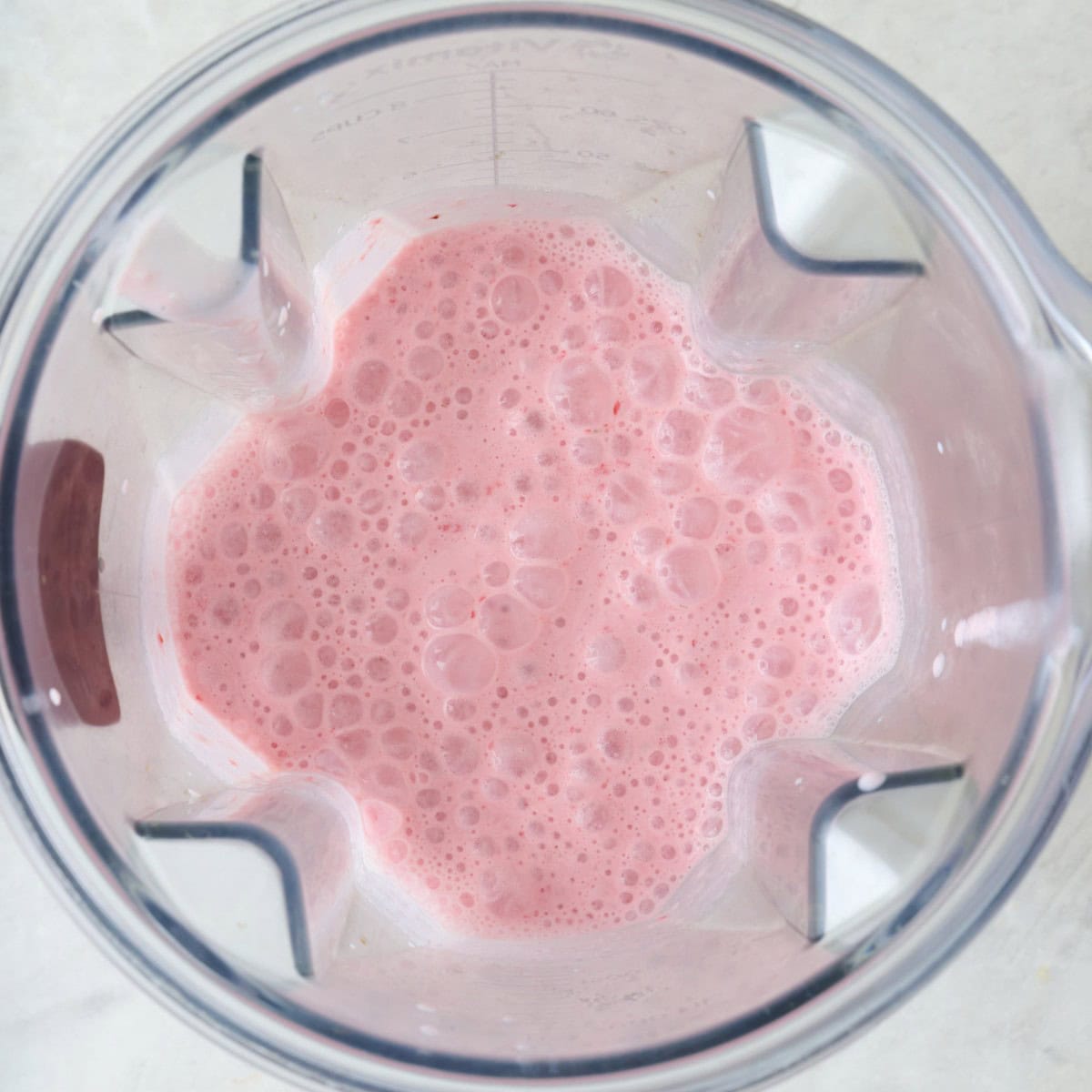 Strawberry banana smoothie ingredients in a blender after blending.