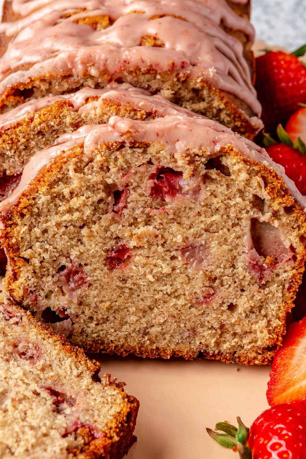 Sliced strawberry pound cake topped with strawberry glaze.