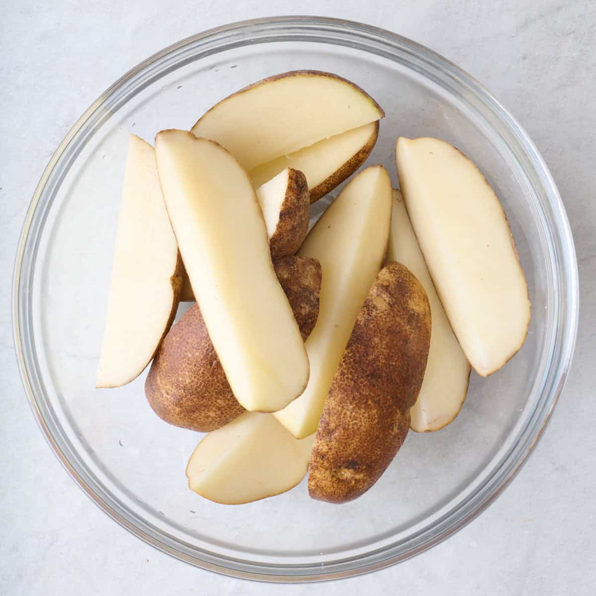 Russet potatoes cut into quarters.