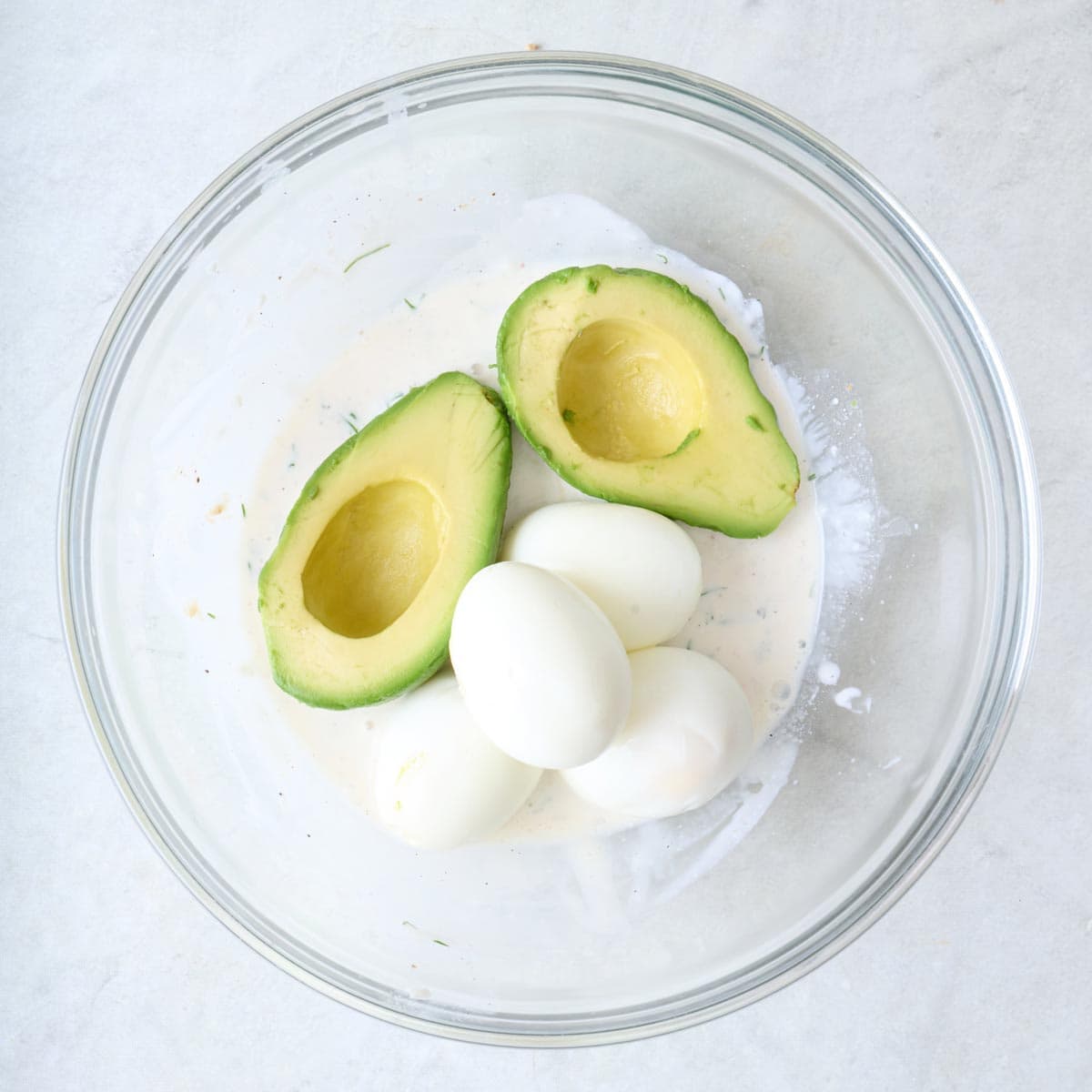 Dressing after mixing with a halved avocado and boiled eggs added on top.