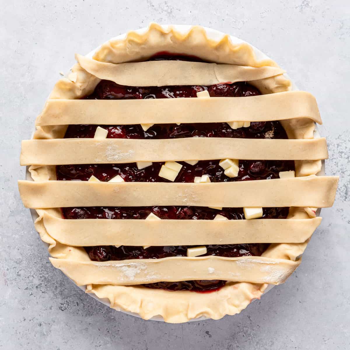 A cherry pie with part of a lattice crust on top.