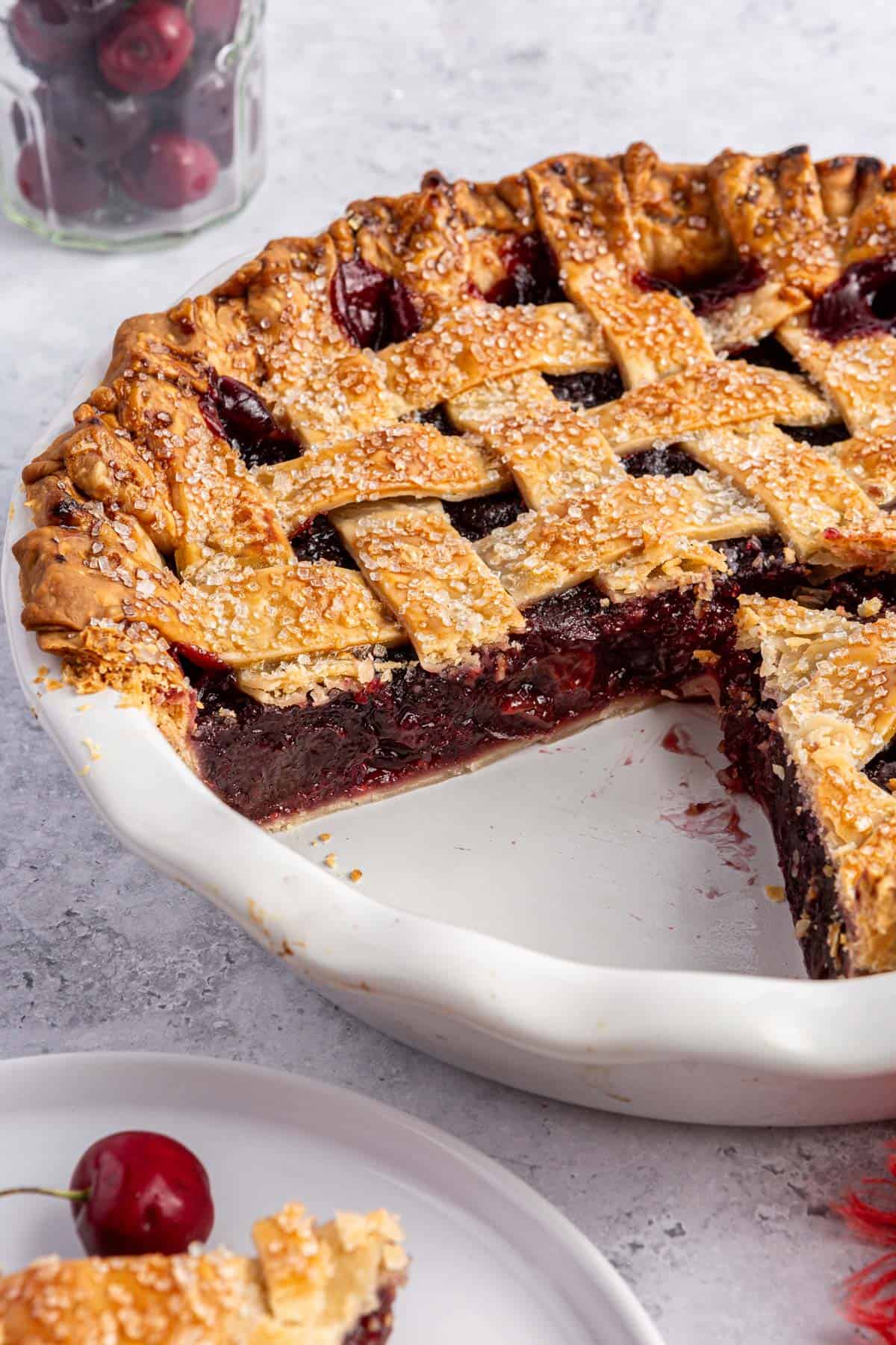 A cherry pie with a slice cut out of it.