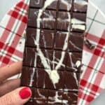 Homemade Dubai Chocolate Bar recipe being hold over a holiday plate by a hand.