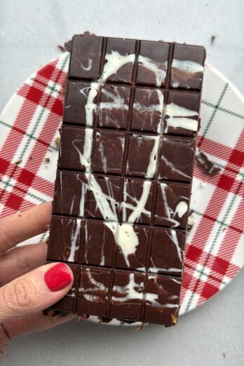 Homemade Dubai Chocolate Bar recipe being hold over a holiday plate by a hand.